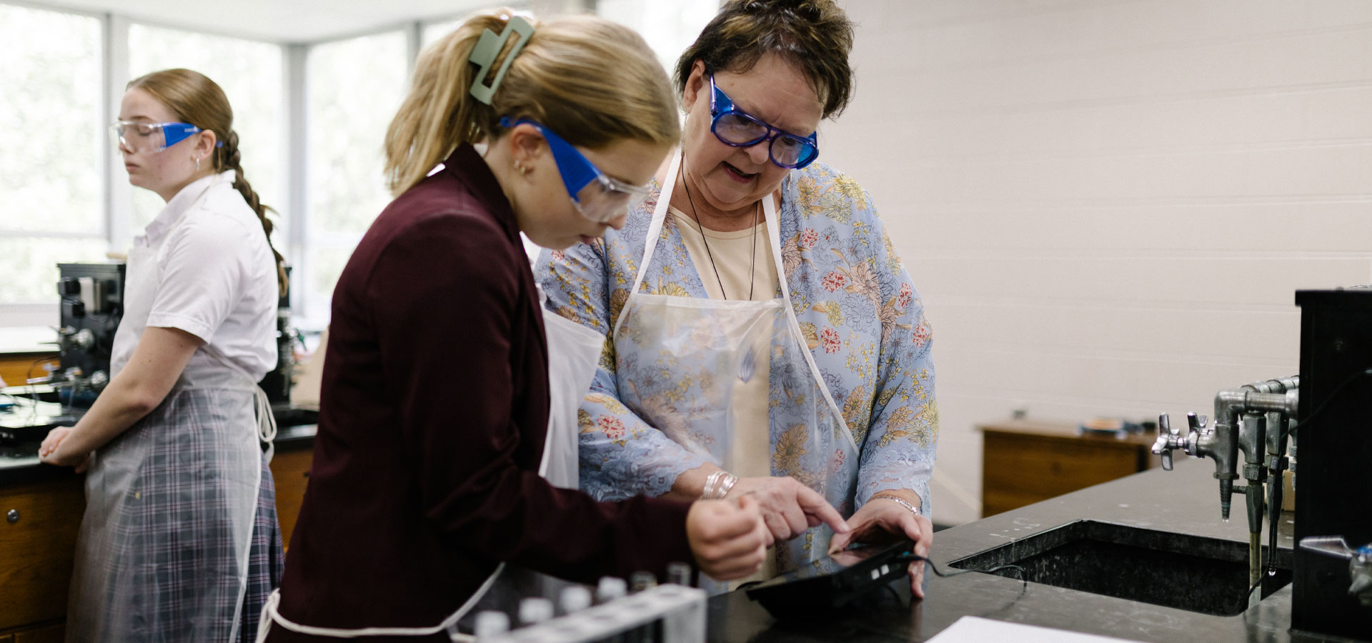 Best boarding schools in the US. Shelley Perry, science teacher at St Bernard, working with a student in class.